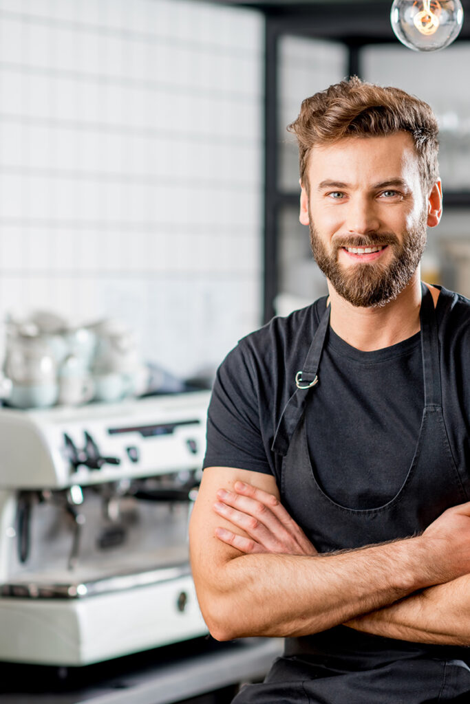Barista steht in seinem Cafe